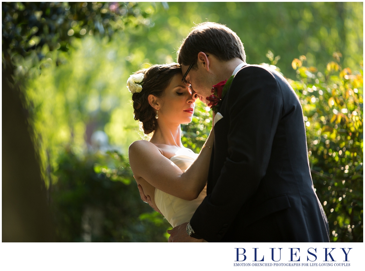 back lit image of bride and groom in garden cliff mautner style
