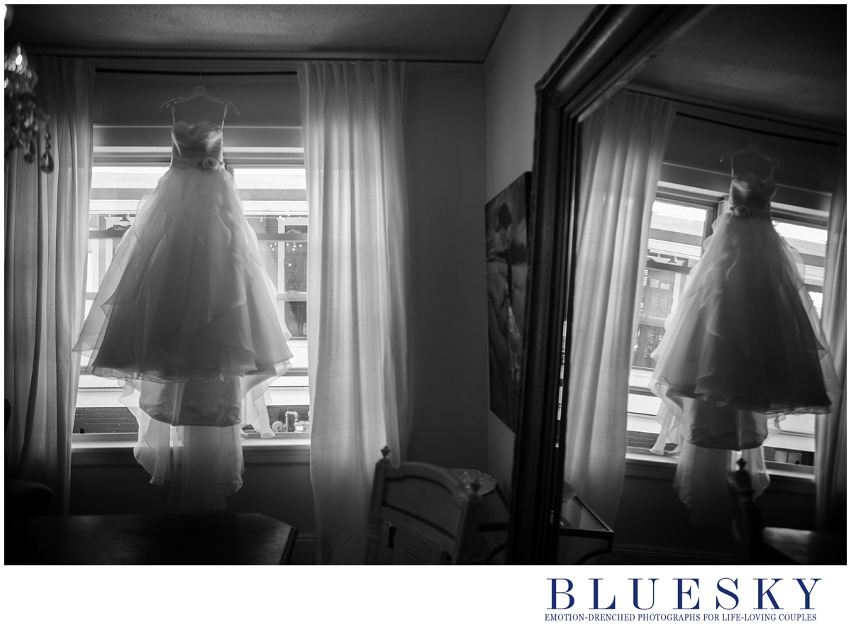 wedding dress hanging in studio white