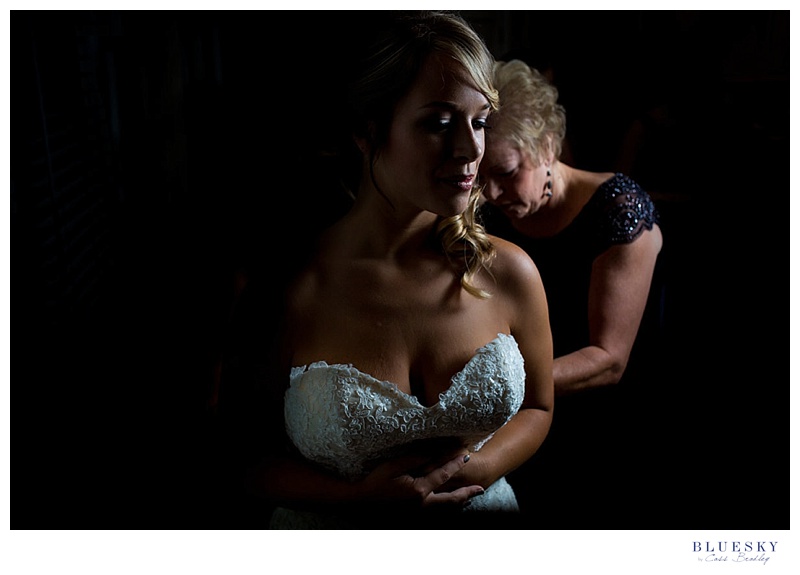 mom helping daughter get ready on wedding day