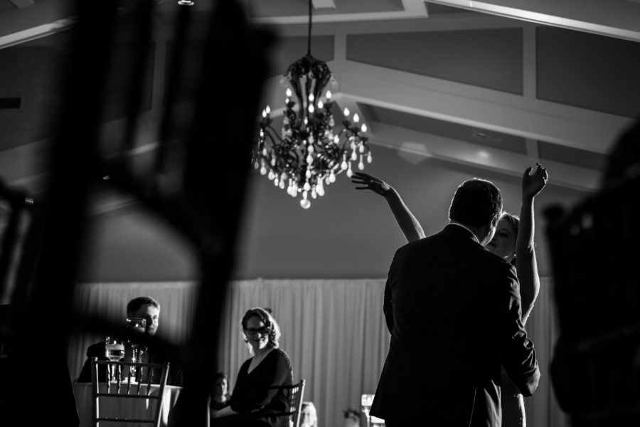 bride and groom black and white dance floor hand in air