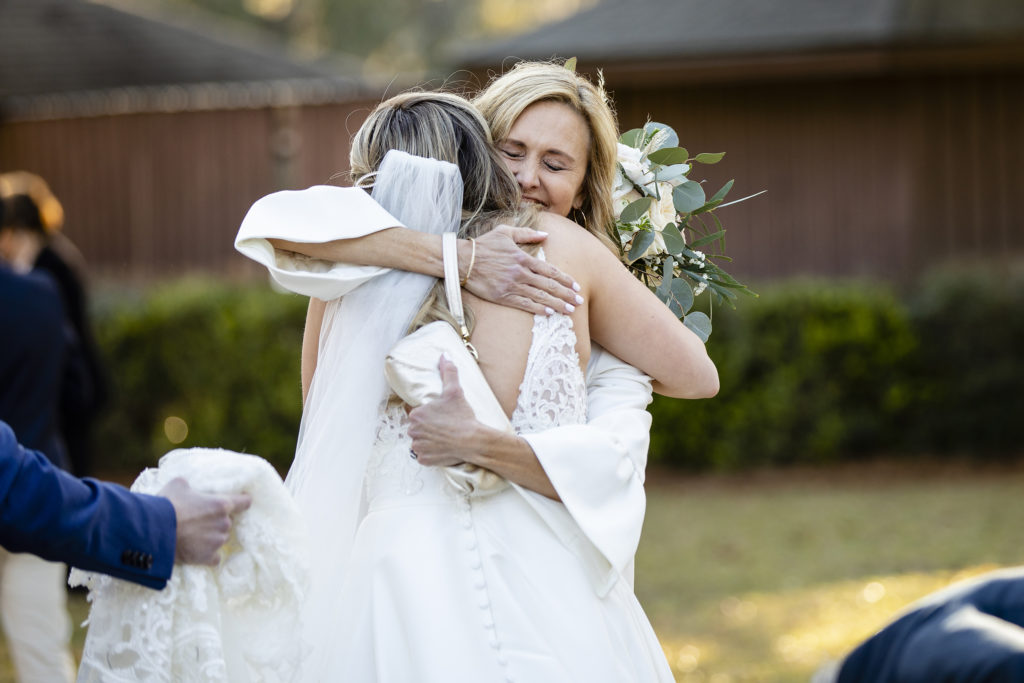 Mother of the groom hugging her new daughter in law on their wedding day