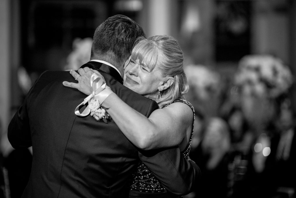 Emotional mother and son dance at his wedding. Daniel Stowe Botanical Gardens wedding reception. Greenhouse and garden weddings